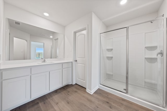 bathroom featuring visible vents, vanity, wood finished floors, recessed lighting, and a stall shower