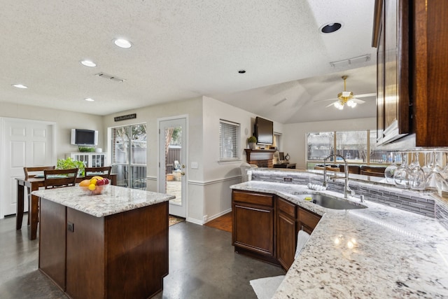 kitchen featuring plenty of natural light, a sink, a textured ceiling, and finished concrete flooring
