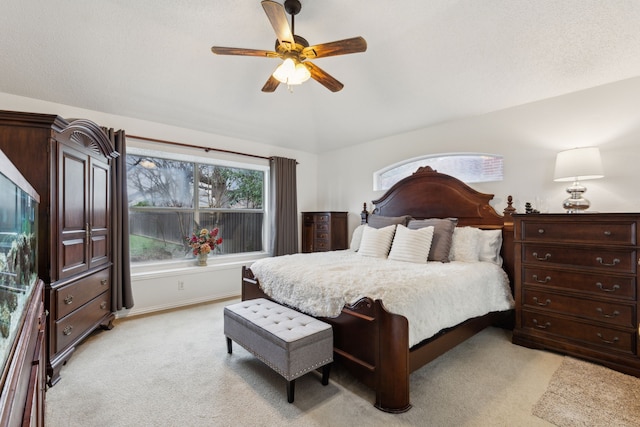 bedroom featuring light colored carpet, baseboards, ceiling fan, and vaulted ceiling