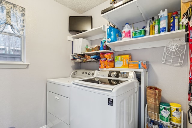 clothes washing area with a textured ceiling, laundry area, and washer and clothes dryer
