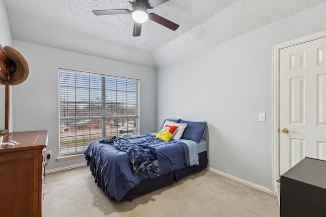 bedroom with baseboards, ceiling fan, a textured ceiling, and light colored carpet