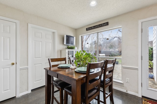 dining space with concrete flooring, a textured ceiling, recessed lighting, and baseboards