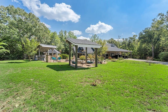 rear view of property featuring a gazebo, a lawn, and a carport