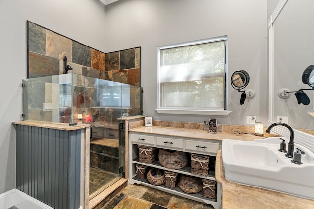 bathroom featuring a sink, stone finish flooring, and a shower stall