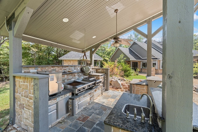 view of patio / terrace featuring a sink, ceiling fan, a grill, and exterior kitchen