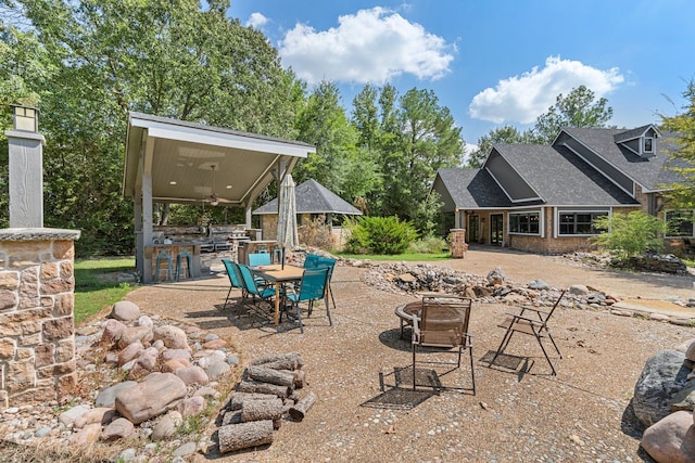 view of patio / terrace with a ceiling fan, an outdoor fire pit, and outdoor dining space