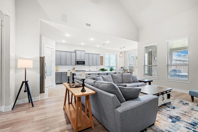 7210 Rustic Rock Rd, Arlington, TX 76001 - living room with high vaulted ceiling, visible vents, baseboards, and light wood-type flooring