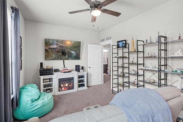 7210 Rustic Rock Rd, Arlington, TX 76001 - living room featuring carpet floors, a ceiling fan, and a warm lit fireplace