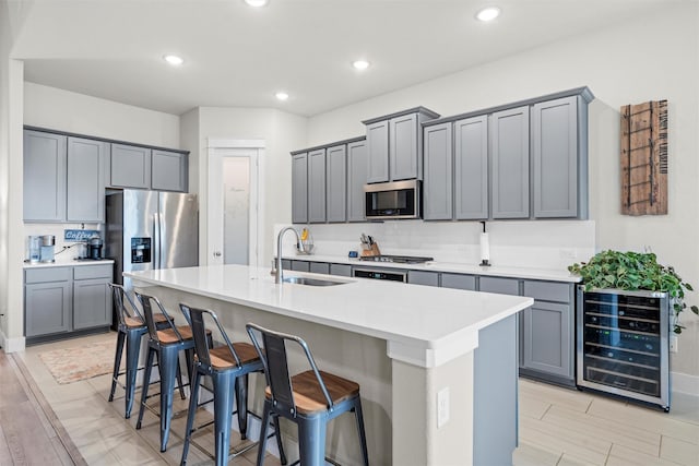 7210 Rustic Rock Rd, Arlington, TX 76001 - kitchen with wine cooler, a breakfast bar, a center island with sink, a sink, and appliances with stainless steel finishes