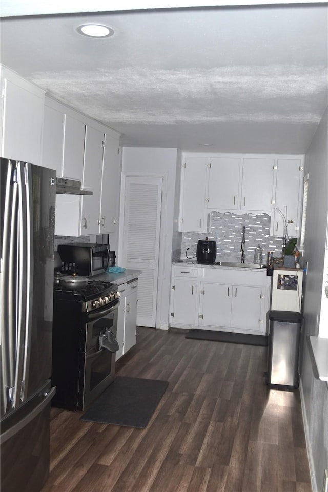 372 Shoreline Dr, Azle, TX 76020 - kitchen with decorative backsplash, appliances with stainless steel finishes, a sink, under cabinet range hood, and white cabinetry