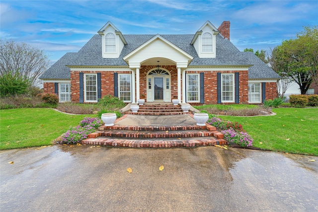 1204 Lakeridge Dr, Ennis, TX 75119 - cape cod home with brick siding, a shingled roof, a front yard, and a chimney