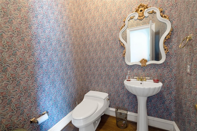 1204 Lakeridge Dr, Ennis, TX 75119 - half bath featuring baseboards, wallpapered walls, and toilet