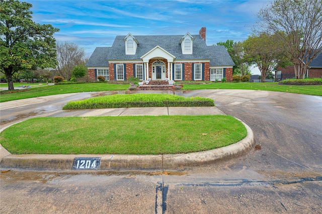 1204 Lakeridge Dr, Ennis, TX 75119 - cape cod home featuring curved driveway, a chimney, a front yard, and brick siding