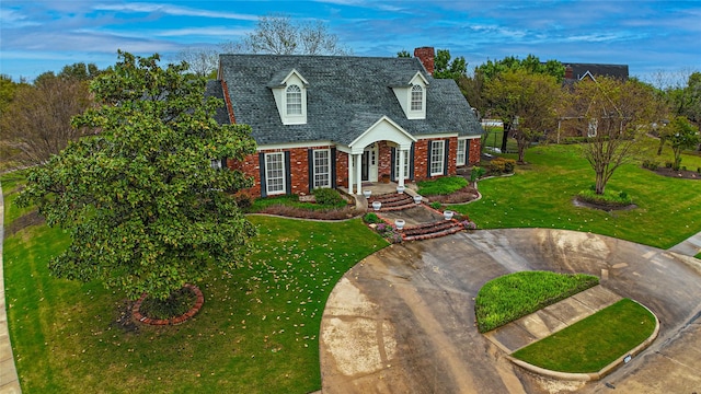 1204 Lakeridge Dr, Ennis, TX 75119 - cape cod house featuring brick siding, a chimney, and a front yard
