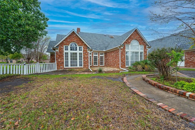 1204 Lakeridge Dr, Ennis, TX 75119 - view of front of property with roof with shingles, fence, a chimney, and brick siding