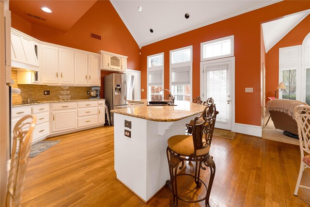 1204 Lakeridge Dr, Ennis, TX 75119 - kitchen featuring visible vents, stainless steel refrigerator with ice dispenser, a sink, and a breakfast bar area