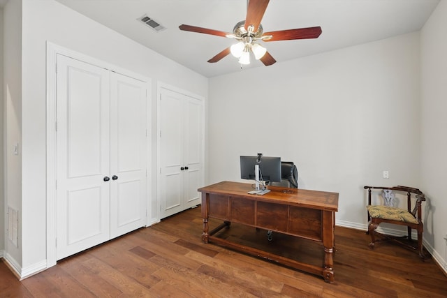 office area with baseboards, ceiling fan, wood finished floors, and visible vents