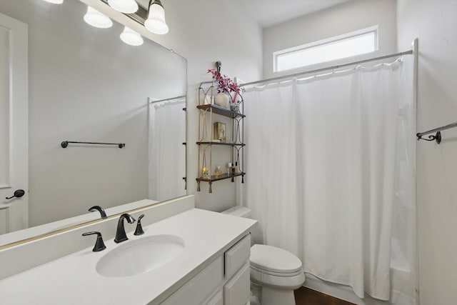 full bath featuring toilet, shower / tub combo with curtain, and vanity