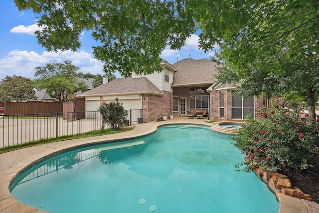 view of swimming pool with fence, a pool with connected hot tub, and a patio area