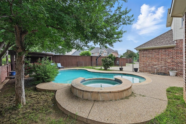 view of swimming pool featuring a fenced backyard and a pool with connected hot tub