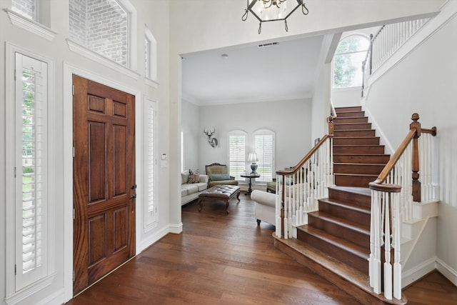 foyer featuring stairs, visible vents, a healthy amount of sunlight, and wood finished floors