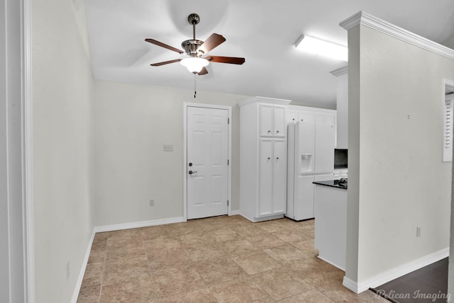 9518 Hackberry Dr, Shreveport, LA 71115 - interior space featuring dark countertops, baseboards, ceiling fan, white cabinets, and white fridge with ice dispenser