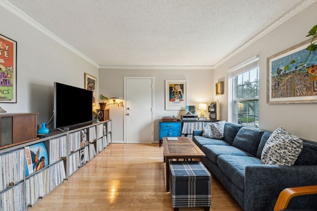 living area with ornamental molding, a textured ceiling, and wood finished floors