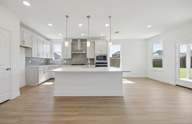 1616 Cottonwood Valley Dr, Celina, TX 75009 - kitchen featuring wall chimney exhaust hood, stainless steel microwave, light wood-type flooring, light countertops, and recessed lighting