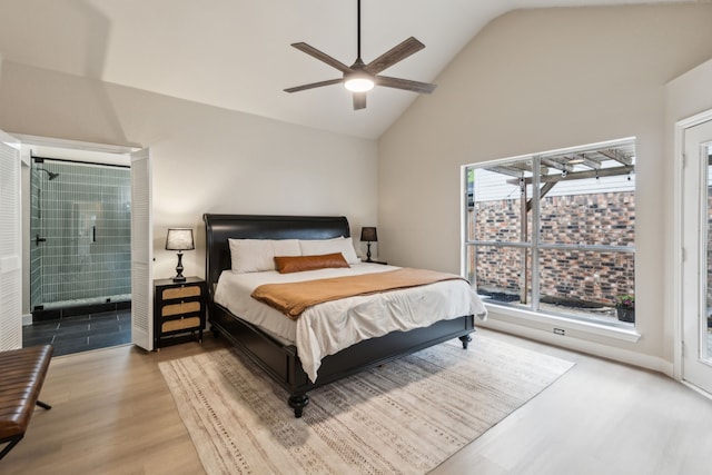 bedroom featuring a ceiling fan, high vaulted ceiling, wood finished floors, and ensuite bathroom