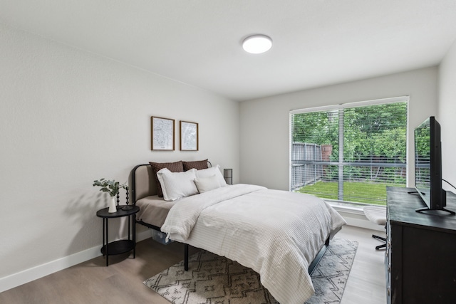 bedroom with baseboards and wood finished floors