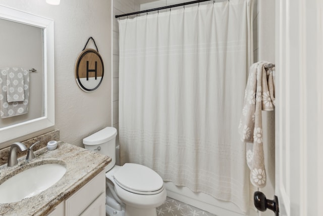 bathroom featuring vanity, a textured wall, toilet, and shower / tub combo with curtain