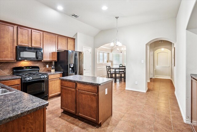 kitchen featuring a sink, dark countertops, black appliances, and brown cabinets