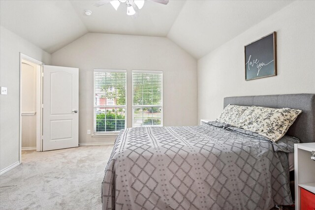 carpeted bedroom with visible vents, lofted ceiling, baseboards, connected bathroom, and a ceiling fan