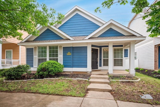bungalow-style home featuring a shingled roof and a porch
