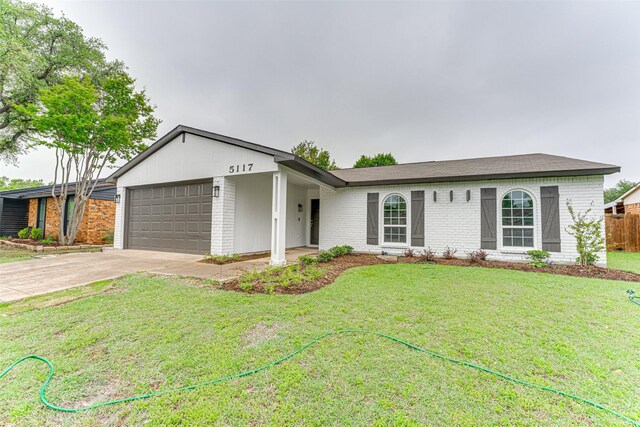 view of front of property featuring concrete driveway, brick siding, an attached garage, and a front lawn