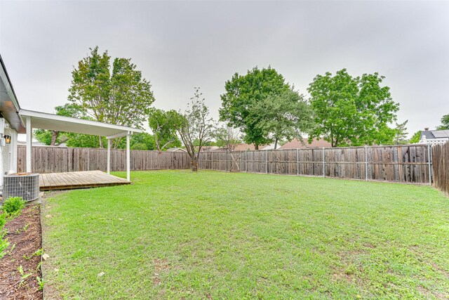 view of yard featuring central AC, a wooden deck, and a fenced backyard