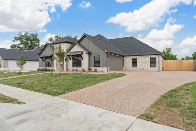view of front of property with fence, an attached garage, a front lawn, board and batten siding, and concrete driveway
