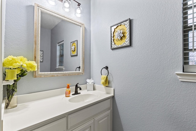 bathroom featuring a textured wall and vanity