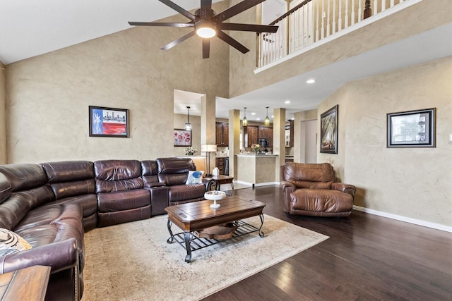 living area featuring a textured wall, ceiling fan, high vaulted ceiling, baseboards, and dark wood-style floors