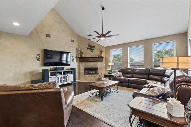 living area with a ceiling fan, visible vents, a fireplace, wood finished floors, and a textured wall