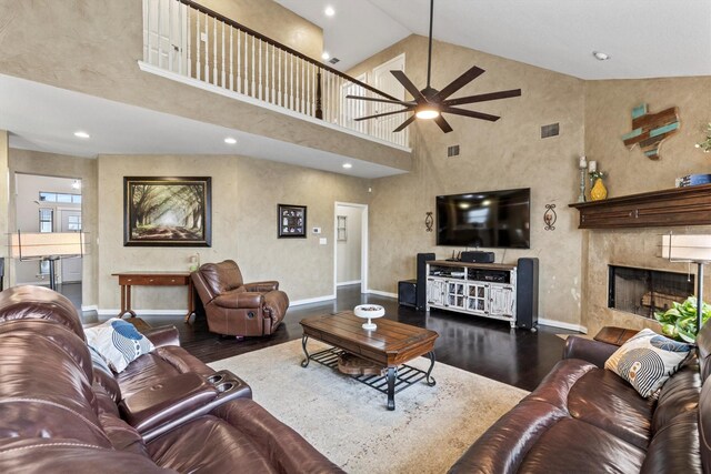 living area with visible vents, wood finished floors, baseboards, ceiling fan, and a premium fireplace