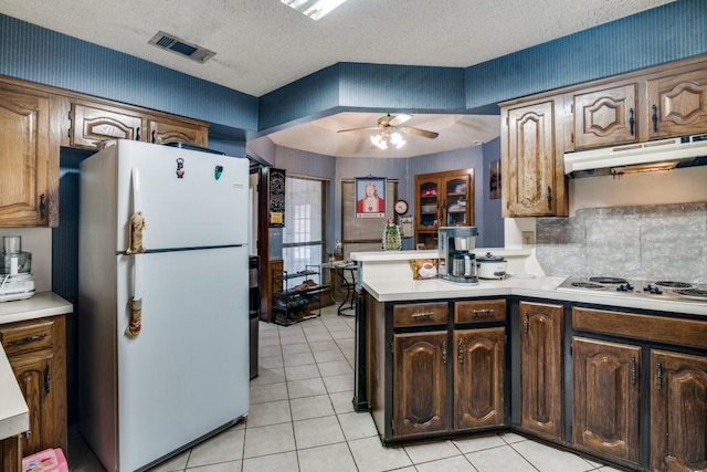 kitchen featuring ceiling fan, visible vents, light countertops, a peninsula, and white appliances