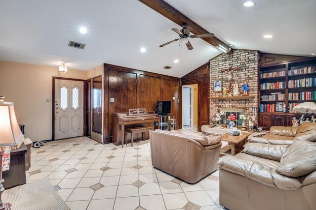 living room featuring vaulted ceiling with beams, a ceiling fan, a brick fireplace, and visible vents