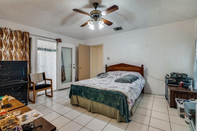 bedroom with light tile patterned floors, a textured ceiling, and visible vents