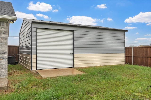 view of outdoor structure with fence and an outbuilding