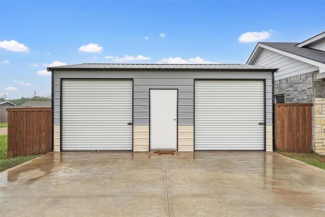 detached garage featuring fence