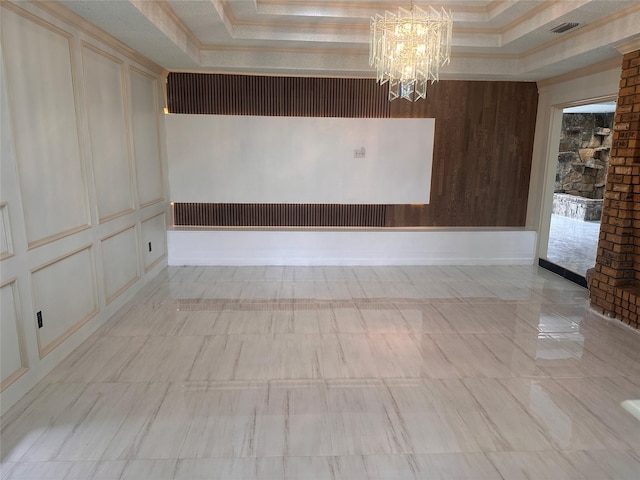 unfurnished room with an inviting chandelier, ornamental molding, a tray ceiling, and visible vents