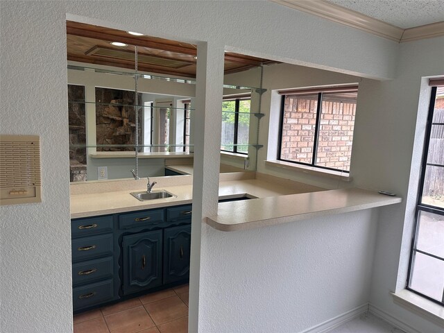 bar featuring wet bar, a sink, light tile patterned floors, ornamental molding, and a textured wall