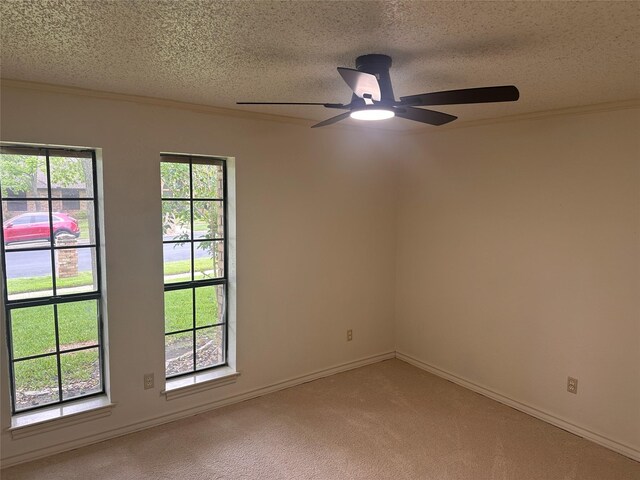 empty room with ornamental molding, a textured ceiling, ceiling fan, and light carpet