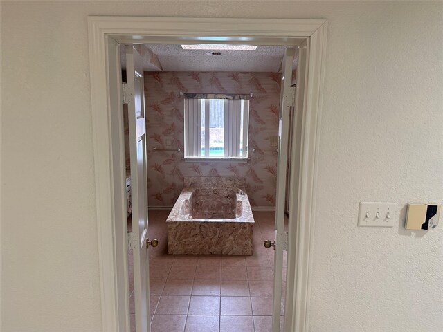 bathroom featuring tile patterned floors, a washtub, and wallpapered walls